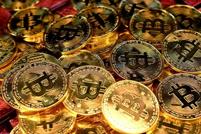 Złote monety z symbolem Bitcoina. Zastanawiasz się, jaka jest cena bitcoin?